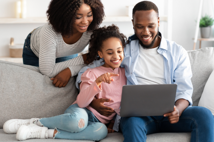 family of three looking at computer and smiling