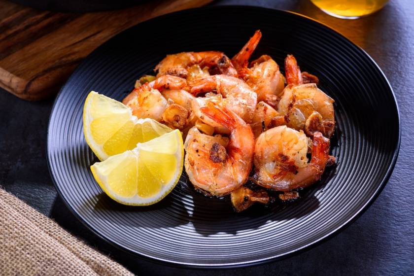 pan seared shrimp on a blue playte side of lemon