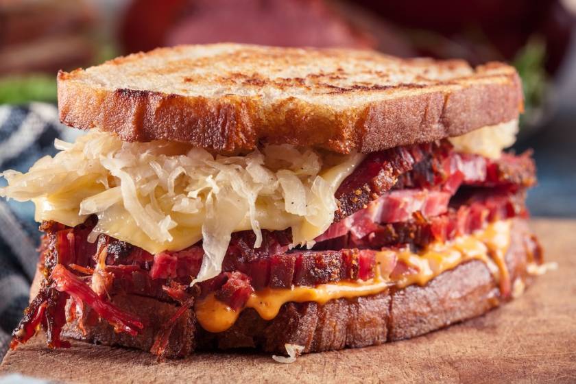 reuben sandwich on wood with corned beef