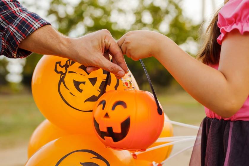 trick or treater with pumpkin bucket
